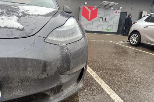 Pelēka automa&scaron;īna ar dubļiem blakus mazgā&scaron;anas stacijai.