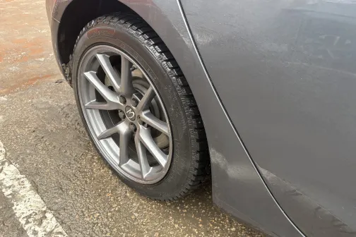 Pelēka automa&scaron;īna, skats uz aizmugurējo riteni uz mitra ceļa.