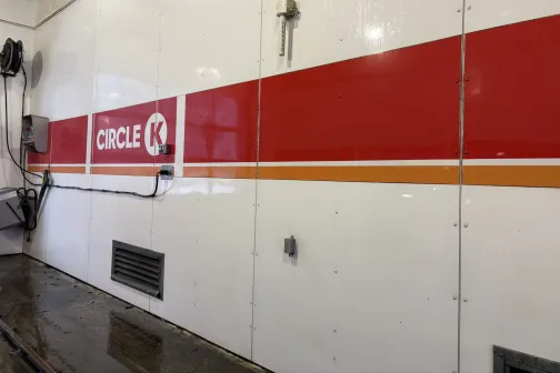 Balta siena auto mazgātavā ar Circle K logotipu.