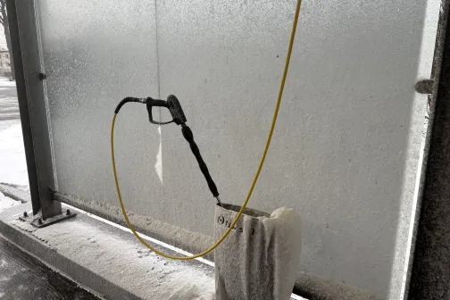 Augstspiediena ūdens pistole pie pa&scaron;apkalpo&scaron;anās automazgātuves.