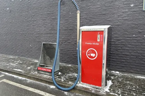 Automa&scaron;īnu mazgātavas putekļsūcējs pie pelēkas sienas.