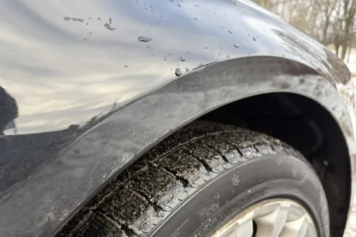 Melnas automa&scaron;īnas netīrā riteņa arka ziemā.