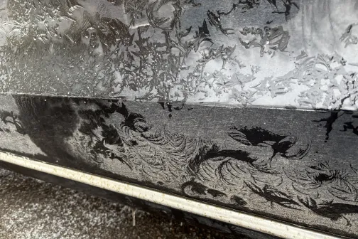 Ietvert putekļains automa&scaron;īnas sāns ar mākslinieciskiem rakstiem.