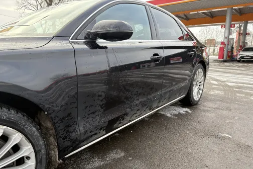 Melns auto pie automazgātavas, sāni netīri ar dubļiem.