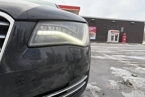 Automa&scaron;īnas priek&scaron;ējais lukturis tuvplānā, fonā automazgātuve.