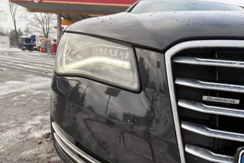 Melnas ma&scaron;īnas priek&scaron;ējā lampa pie auto mazgātuves ziemā.