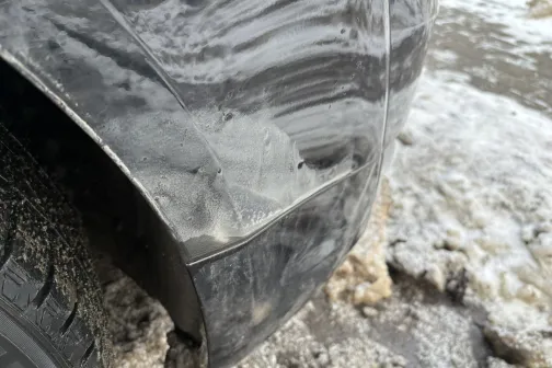 Netīrs auto spārns ar sāls un netīrumu traipiem.