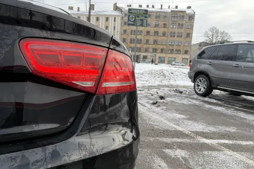 Melna automa&scaron;īna sniegotā stāvvietā ar aizmugurējo lukturi tuvu skatā.