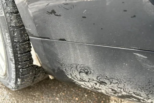 Netīrs auto ar dubļu &scaron;ļakatām uz durvīm un riepām.