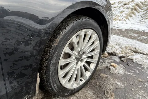 Auto riteņa tuvplāns uz sniegota ceļa.