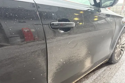 Melnas automa&scaron;īnas sānu durvis un riteņi, ar netīrumiem.