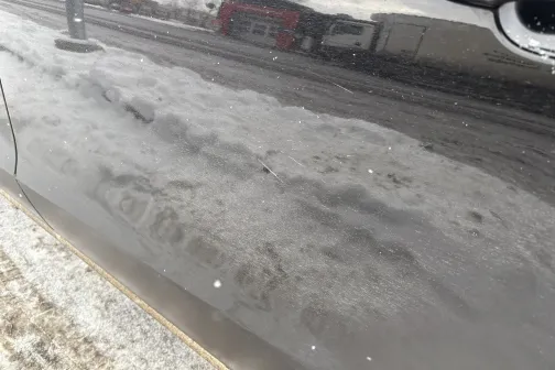 Netīrs auto sāns ar dubļiem un sniega atspīdumiem.