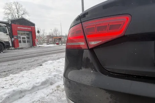 Melnas automa&scaron;īnas aizmugure netālu no sarkanas automazgātavas ziemas dienā.