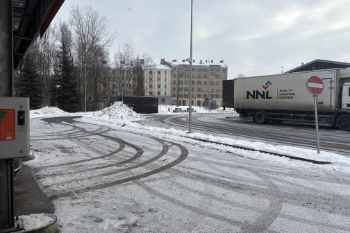 Sniegots auto stāvlaukums ar kravas auto fonā.