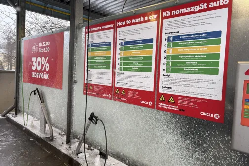 Automazgātuves skalo&scaron;anas laistītājs un instrukcijas uz sienas.