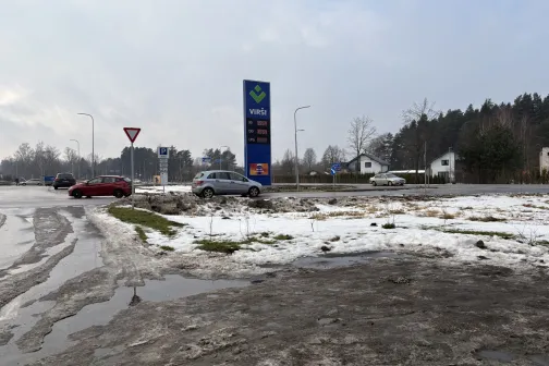 Ziemaina ceļa ainava ar automa&scaron;īnām un ceļa zīmēm.