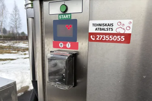 Maksājumu automāts automazgātavā ziemas dienā.