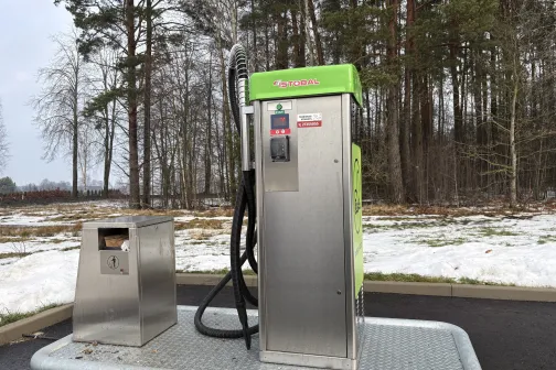 Mazgā&scaron;anas automāts meža fonā ar zaļu aug&scaron;daļu.