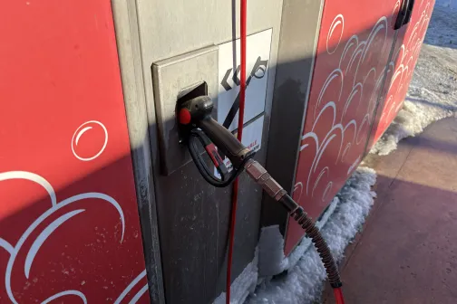 Sarkanas automazgātuves augstspiediena ūdens pistole pie sienas.