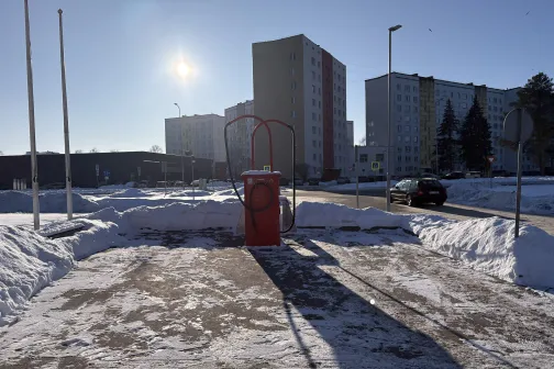 Automazgā&scaron;anas stacija saulainā ziemas dienā ar daudzdzīvokļu mājām fonā.