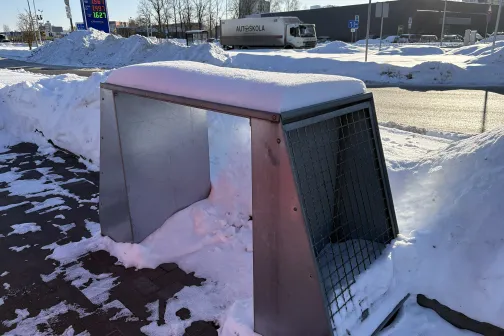 Metāla konstrukcija sniegā blakus ceļam ziemas dienā.