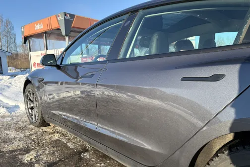 Pelēks auto saulainā dienā pie automazgātavas ziemā.