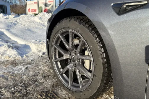 Automobiļa riepa ziemas apstākļos pie auto mazgātuves.