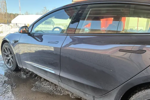 Metāliski pelēka automa&scaron;īna netīrumu aplieta, saulainā dienā pie auto mazgātavas.