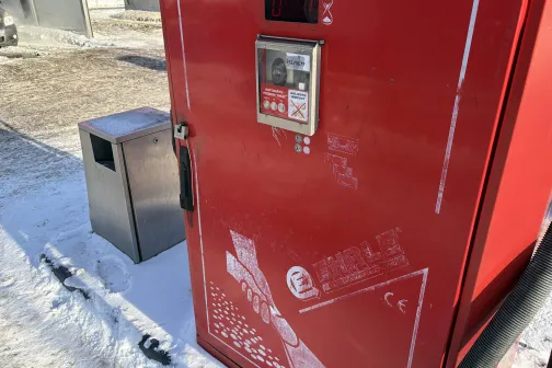 Sarkans automāts ārā sniegā pie auto mazgā&scaron;anas stacijas.