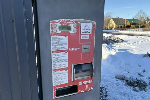 Sarkans maksājumu automāts pie automazgātavas ziemā.