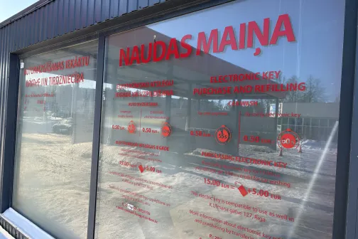 Logu stikli ar sarkanām uzlīmēm un tekstu par pakalpojumiem.