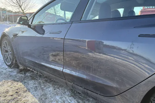 Auto sāni ziemas saules gaismā, uz sniegota seguma.