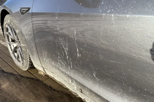 Netīrs sudraba auto sāns ar dubļiem un &scaron;ļakatām.