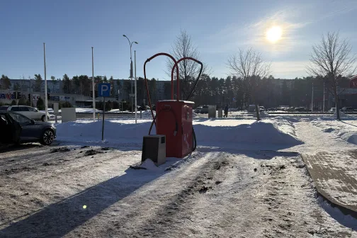 Sniegots autostāvvieta ar putekļsūcēju automa&scaron;īnām, saule debesīs.