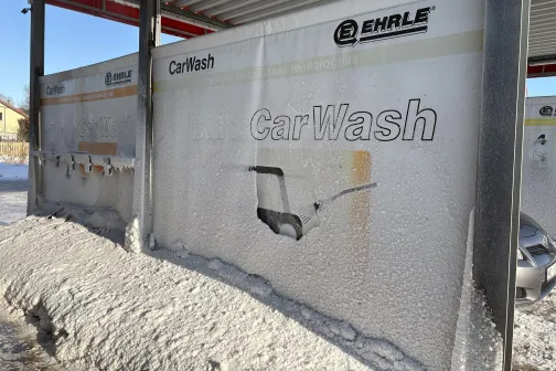 Automazgātuves stendi zem metāla jumta ap sniegotu vidi.