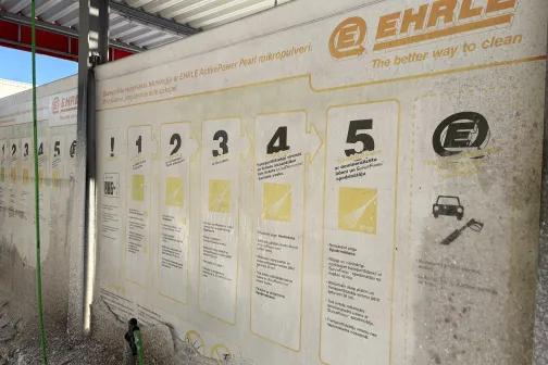 Automa&scaron;īnu mazgātavas instrukcijas uz sienas, virs tām logotips "EHRLE".