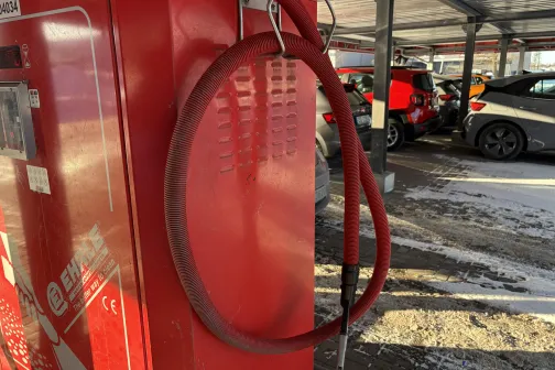 Sarkanās automazgātavas putekļu sūcēja  iekārtas &scaron;ļūtene saulainā dienā.