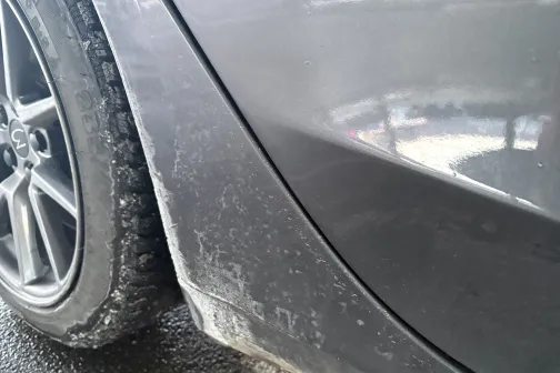 Netīra automa&scaron;īnas virsbūves detaļa ar dubļiem.