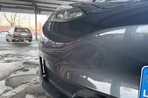 Spīdīgas automa&scaron;īnas priek&scaron;ējais stūris zem nojumes.