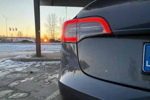 Pelēkas automa&scaron;īnas aizmugure ziemas saulrietā.