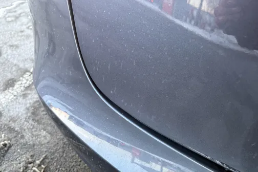 Auto aizmugurējais spārns ar netīrumiem ziemas fonā.