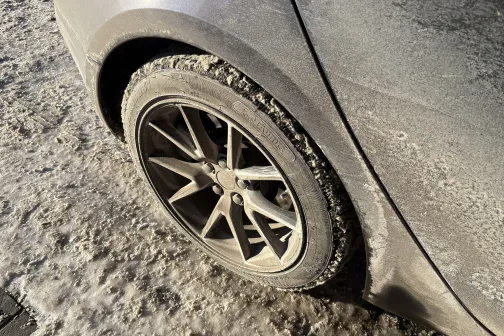 Netīrs automa&scaron;īnas rats apklāts ar smiltīm un sāls.