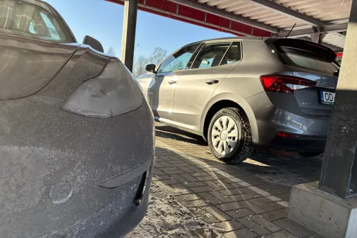 Divas netīras automa&scaron;īnas stāvvietā saulainā dienā.