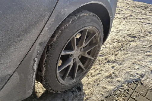 Netīrs automa&scaron;īnas rats uz sniegota ceļa.