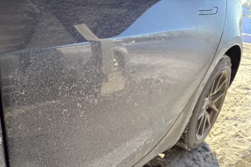 Netīrs automa&scaron;īnas sāns ar putekļainu spoguli saulainā dienā.