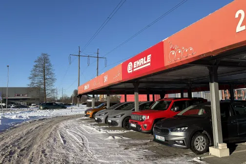 Autostāvvietā rindā novietoti dažādi automobiļi.