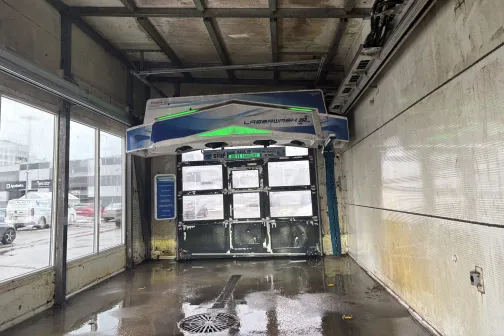 Auto mazgātuves iek&scaron;puse ar mitru grīdu un lieliem logiem.