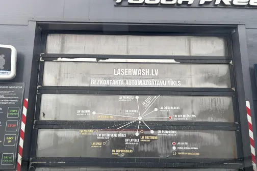 Automātiskās mazgā&scaron;anas durvis ar norādēm un tekstu uz stikla.