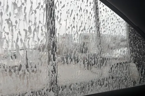 Putota automa&scaron;īnas loga stikla tīrī&scaron;ana.