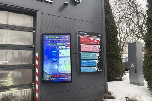Automa&scaron;īnu mazgātavas informatīvie ekrāni pie ēkas sienas ziemā.